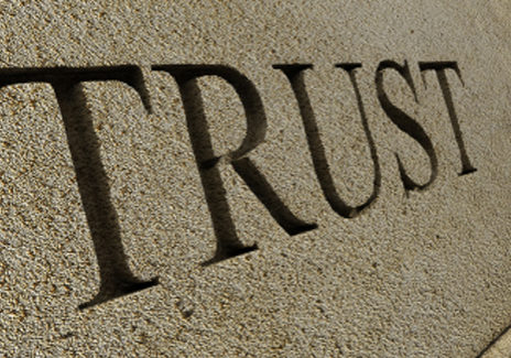 The word TRUST carved into a stone wall. 3D render with HDRI lighting and raytraced textures.